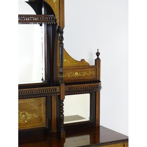 1628 - A late 19thC / early 20thC rosewood sideboard with a mirrored back, pierced galleries, turned suppor... 