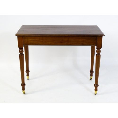 1620 - An early 20thC mahogany side table with a moulded rectangular top above four turned tapering legs te... 