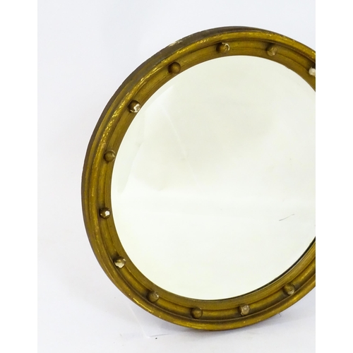 1648 - A late 19thC / early 20thC circular gilt mirror with applied ball decoration. 24