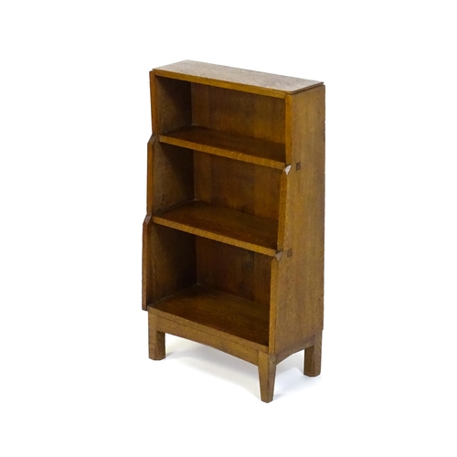 1608 - An Arts & Crafts, Cotswold School, oak waterfall style bookcase raised on four tapering legs. 20