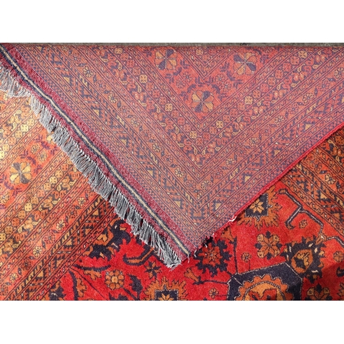 1493 - Carpet / Rug : A large red ground carpet with central repeated floral motifs with banded borders of ... 