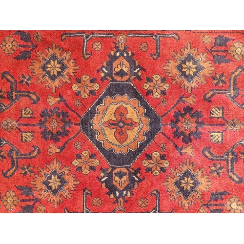 1493 - Carpet / Rug : A large red ground carpet with central repeated floral motifs with banded borders of ... 