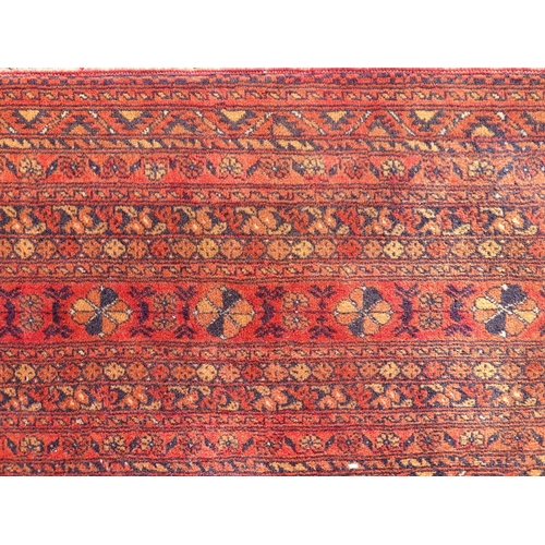 1493 - Carpet / Rug : A large red ground carpet with central repeated floral motifs with banded borders of ... 