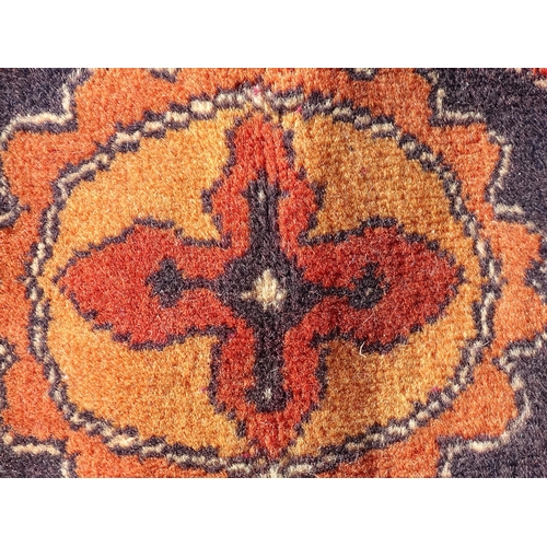 1493 - Carpet / Rug : A large red ground carpet with central repeated floral motifs with banded borders of ... 