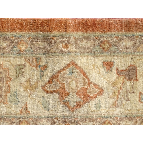 1511 - Carpet / Rug : A wool carpet, the salmon pink ground decorated with floral and foliate detail, with ... 