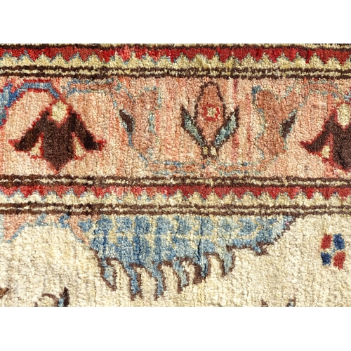 1513 - Carpet / Rug : A wool rug, the beige ground with foliate detail, with salmon ground border with scro... 