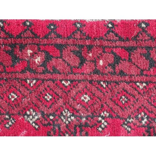 1514 - Carpet / Rug : A red ground runner with repeated geometric motifs and medallions. Approx. 115