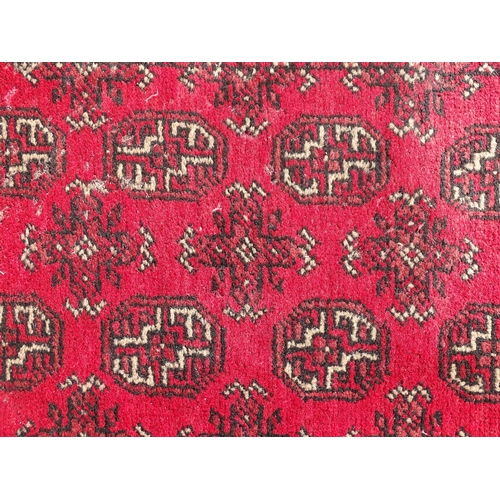 1514 - Carpet / Rug : A red ground runner with repeated geometric motifs and medallions. Approx. 115