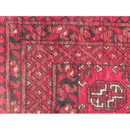 1514 - Carpet / Rug : A red ground runner with repeated geometric motifs and medallions. Approx. 115