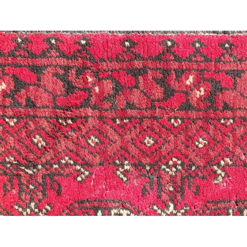 1514 - Carpet / Rug : A red ground runner with repeated geometric motifs and medallions. Approx. 115