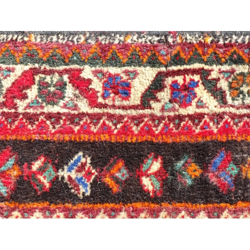 1518 - Carpet / Rug : A red ground rug decorated with central vignette bordered by stylised floral and foli... 