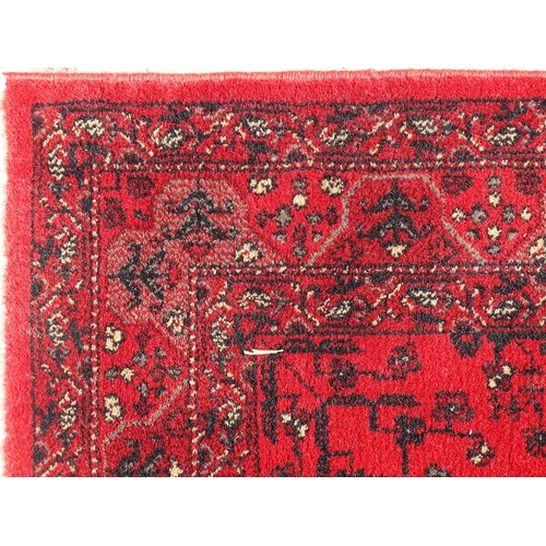 1526 - Carpet / Rug : A red ground rug with stylised floral and foliate detail.  29