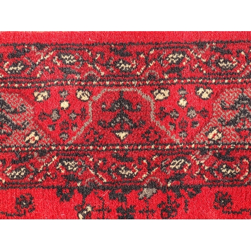 1526 - Carpet / Rug : A red ground rug with stylised floral and foliate detail.  29