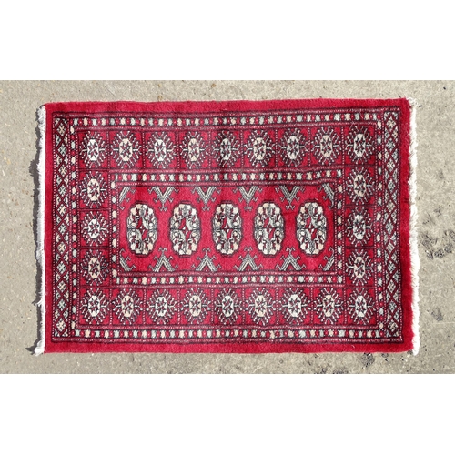 1527 - Carpet / Rug : A red ground rug with central repeated medallions further repeated medallions  to bor... 