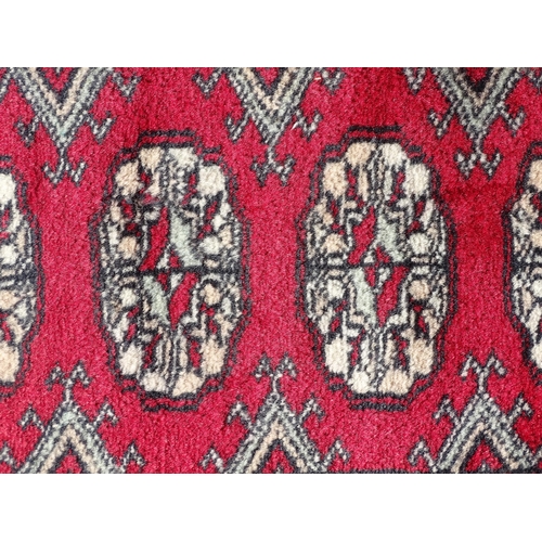 1527 - Carpet / Rug : A red ground rug with central repeated medallions further repeated medallions  to bor... 