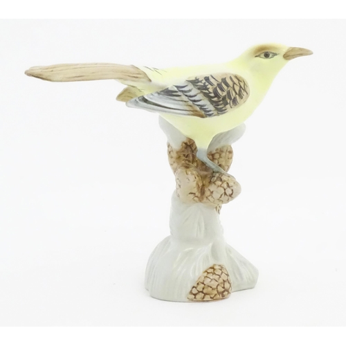 166 - A Royal Dux model of a yellow bird perched on a branch with pine cones. Marked under. Approx. 6