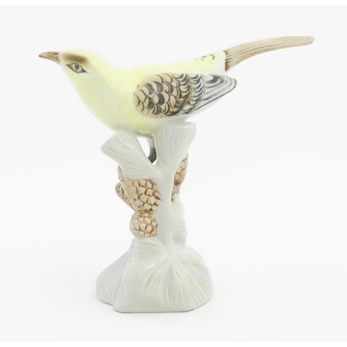 166 - A Royal Dux model of a yellow bird perched on a branch with pine cones. Marked under. Approx. 6