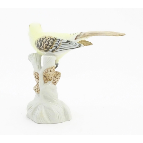 166 - A Royal Dux model of a yellow bird perched on a branch with pine cones. Marked under. Approx. 6