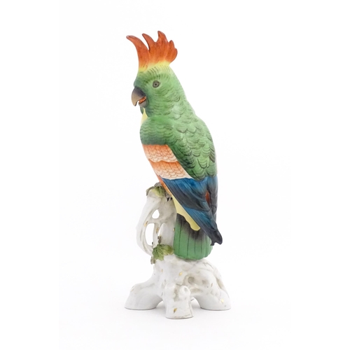 175 - A Capodimonte model of a Parrot with green, yellow, red and blue feathers perched on branch. Marked ... 