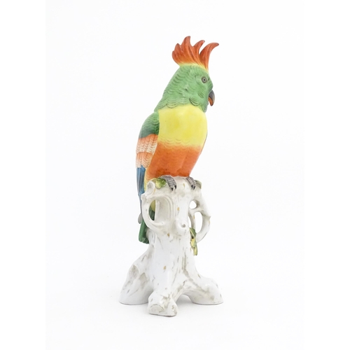 175 - A Capodimonte model of a Parrot with green, yellow, red and blue feathers perched on branch. Marked ... 