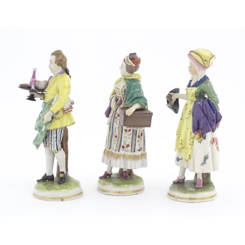 181 - Three Continental figures comprising a woman holding a box, a woman holding a tricorn hat and a man ... 