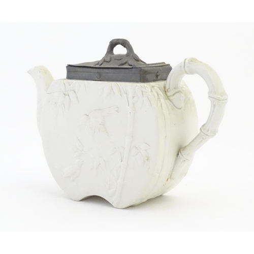 205 - A Victorian Copeland Spode bisque teapot with Aesthetic period decoration depicting birds and bamboo... 