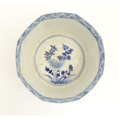 238 - A Chinese blue and white bowl of octagonal form decorated with figures and vases of flowers in bloom... 