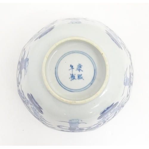 238 - A Chinese blue and white bowl of octagonal form decorated with figures and vases of flowers in bloom... 