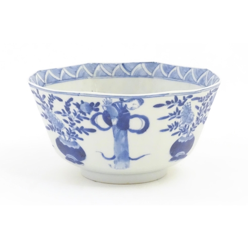 238 - A Chinese blue and white bowl of octagonal form decorated with figures and vases of flowers in bloom... 