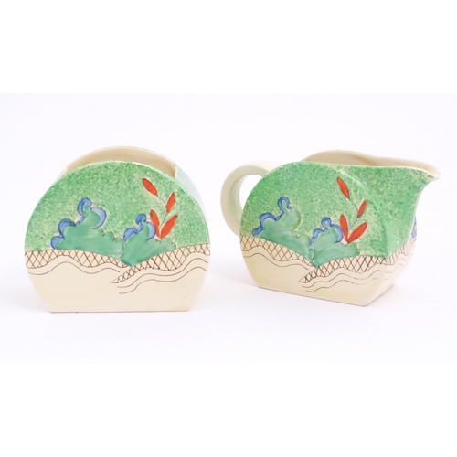 79 - A Clarice Cliff milk jug and sugar bowl decorated in the Chalet pattern. Marked under. Sugar bowl ap... 