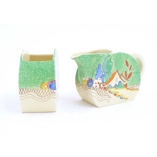 79 - A Clarice Cliff milk jug and sugar bowl decorated in the Chalet pattern. Marked under. Sugar bowl ap... 