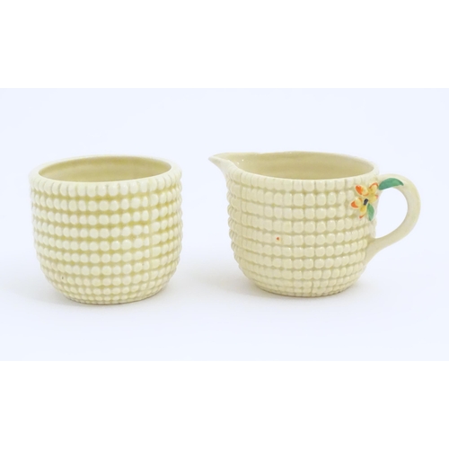 81 - A Clarice Cliff sugar bowl and cream jug in the Corncob pattern. Together with a Royal Staffordshire... 