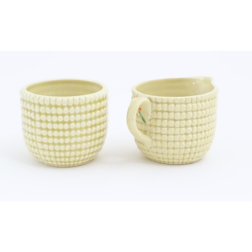 81 - A Clarice Cliff sugar bowl and cream jug in the Corncob pattern. Together with a Royal Staffordshire... 