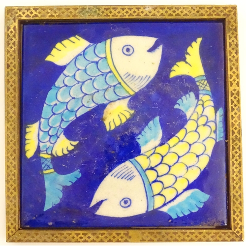 129 - Two Continental tiles with a cobalt blue ground, one decorated with two fish, the other with foliate... 