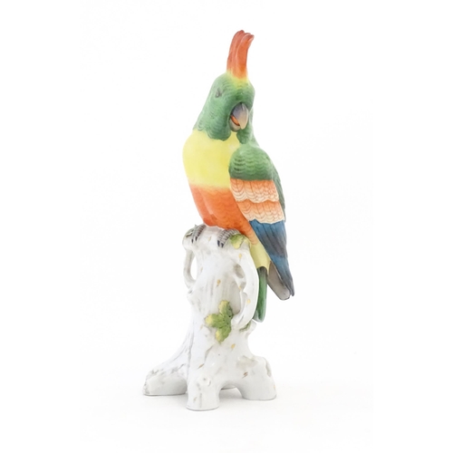 175 - A Capodimonte model of a Parrot with green, yellow, red and blue feathers perched on branch. Marked ... 