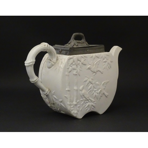 205 - A Victorian Copeland Spode bisque teapot with Aesthetic period decoration depicting birds and bamboo... 