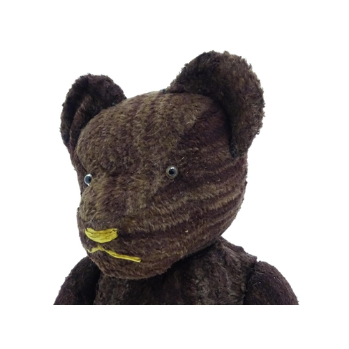 1427 - Toy: A 20thC straw filled teddy bear with stitched nose, mouth and claws, pad paws and articulated l... 