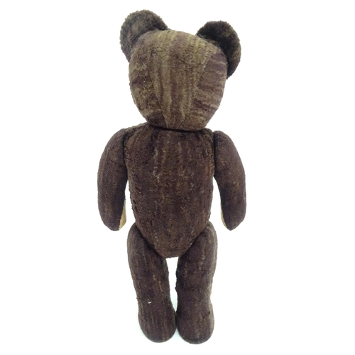 1427 - Toy: A 20thC straw filled teddy bear with stitched nose, mouth and claws, pad paws and articulated l... 