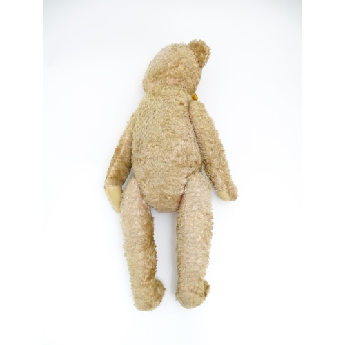 1428 - Toy: A large early 20thC straw filled mohair teddy bear, with stitched nose and mouth, pad paws and ... 