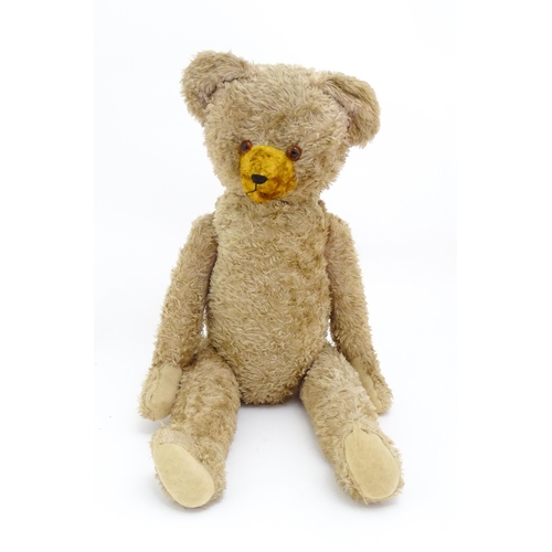 1428 - Toy: A large early 20thC straw filled mohair teddy bear, with stitched nose and mouth, pad paws and ... 