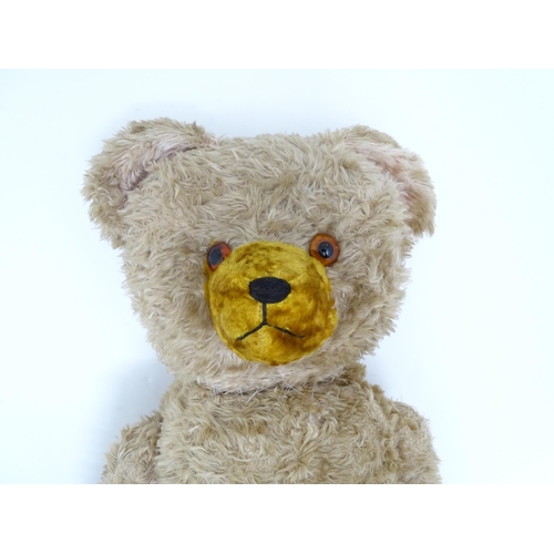 1428 - Toy: A large early 20thC straw filled mohair teddy bear, with stitched nose and mouth, pad paws and ... 