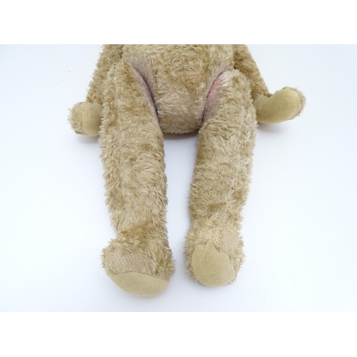 1428 - Toy: A large early 20thC straw filled mohair teddy bear, with stitched nose and mouth, pad paws and ... 