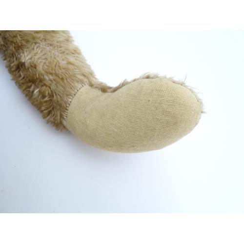 1428 - Toy: A large early 20thC straw filled mohair teddy bear, with stitched nose and mouth, pad paws and ... 