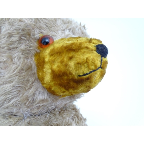 1428 - Toy: A large early 20thC straw filled mohair teddy bear, with stitched nose and mouth, pad paws and ... 