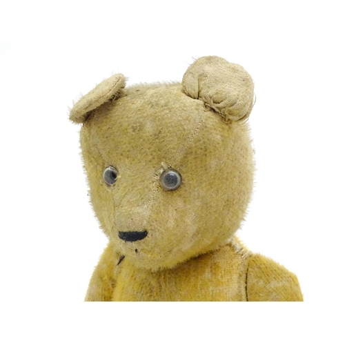 1429 - Toys: An early 20thC straw filled teddy bear with glass eyes, stitched nose and mouth and growler me... 