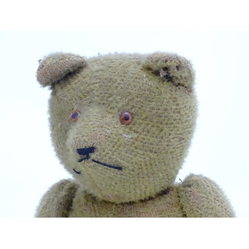 1429 - Toys: An early 20thC straw filled teddy bear with glass eyes, stitched nose and mouth and growler me... 