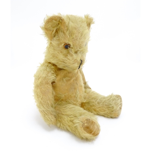 1432 - Toy: A 20thC straw filled mohair teddy bear with stitched nose and mouth, pad paws and articulated l... 