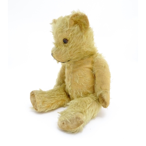 1432 - Toy: A 20thC straw filled mohair teddy bear with stitched nose and mouth, pad paws and articulated l... 