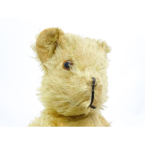 1432 - Toy: A 20thC straw filled mohair teddy bear with stitched nose and mouth, pad paws and articulated l... 