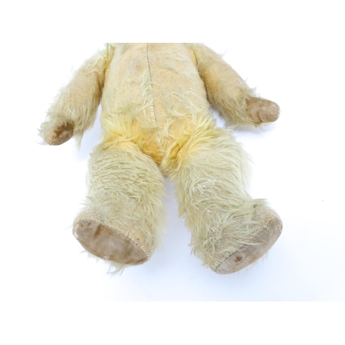 1432 - Toy: A 20thC straw filled mohair teddy bear with stitched nose and mouth, pad paws and articulated l... 